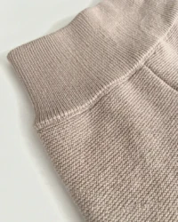 Szeroki ściągacz w pasie beżowych spodni merino dziecięcych z bliska