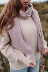 Beżowy sweter merino damski na kobiecie i różowy szal z metką, zbliżenie w plenerze